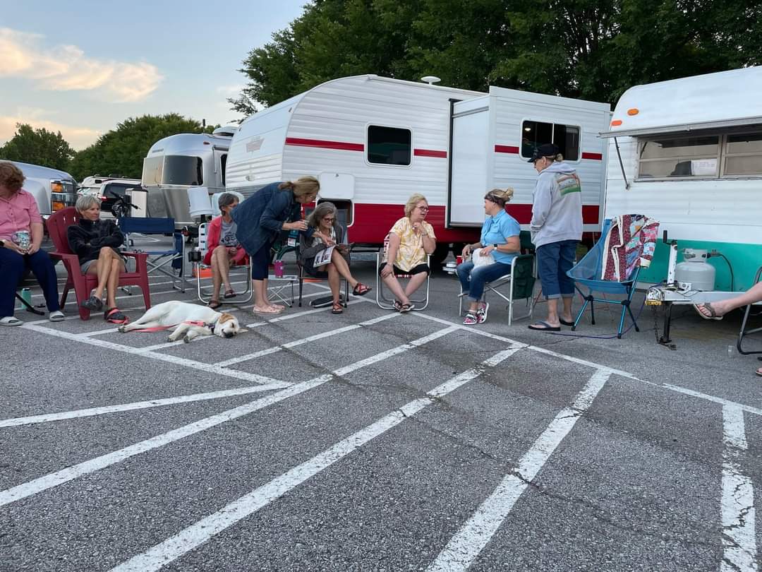 Travel with us - group of women gathering around RVs