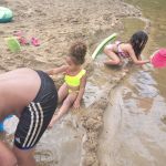 kids playing in the sand at the river