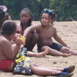 kids eating siting in the sun on the beach