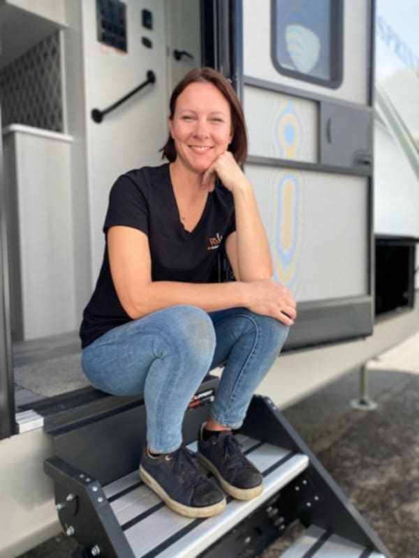 Woman sitting on the steps of an RV